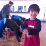 a boy smiling after doing a downward dog tunner