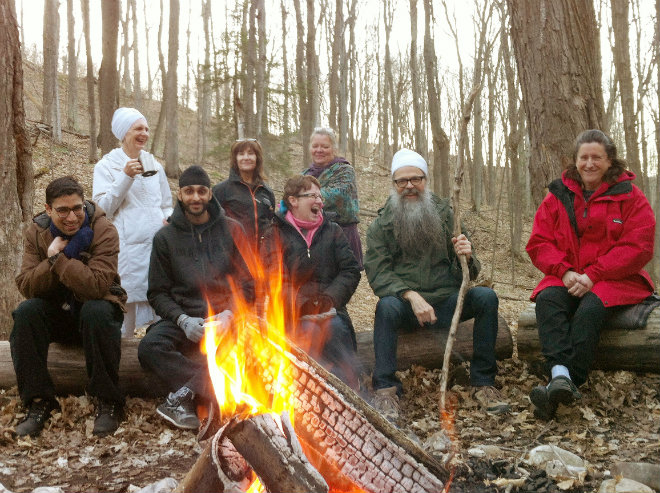 yoga retreat in Ontario Canada, with participants around the bonfire enjoying yogi tea and the fire