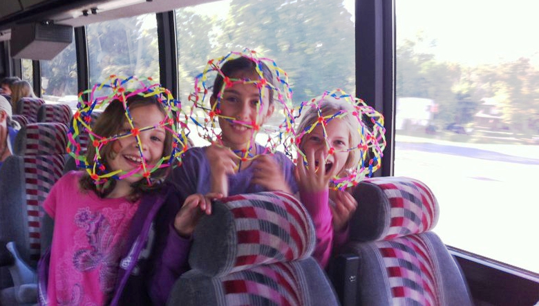 3 kids put the breathing ball over their heads and look at ehe camera laughing